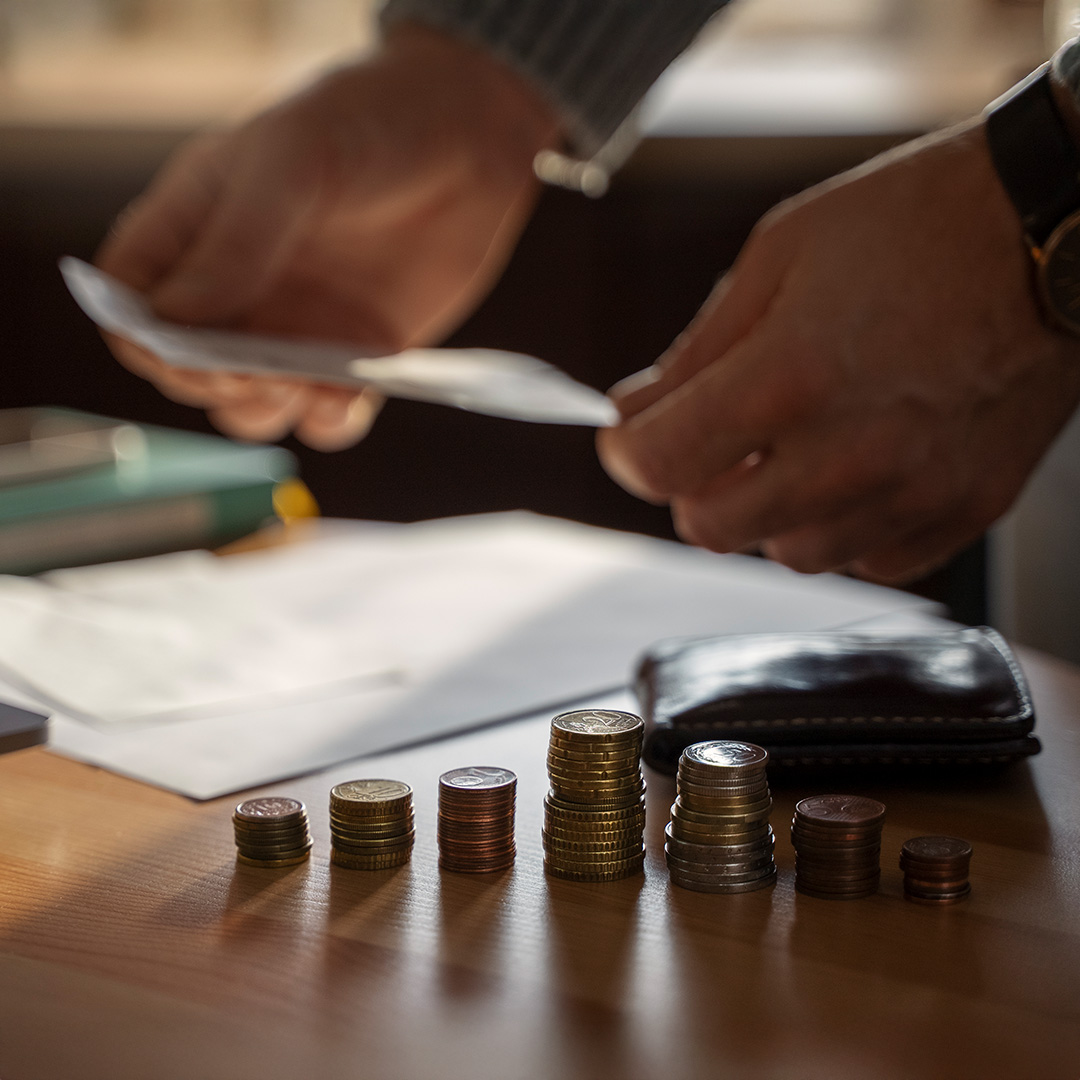 Mężczyzna liczący pieniądze i wypełniający dokumenty podatkowe